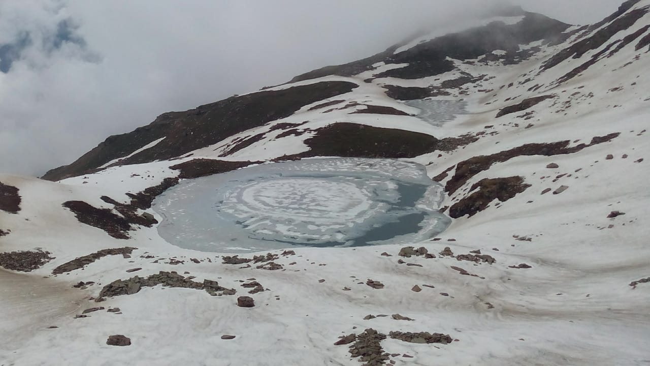 Reflection of clear sky on a frozen lake with snow covered ground on surrounding