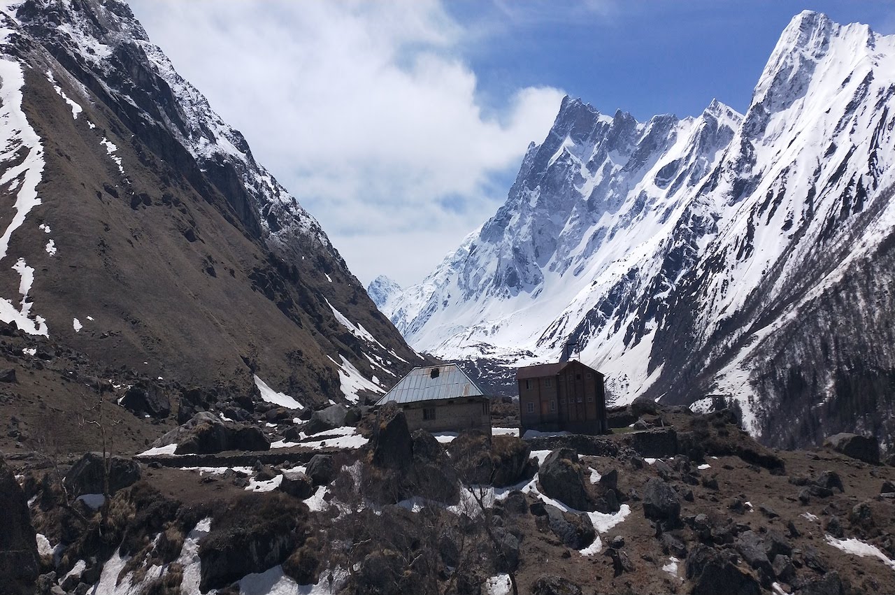 Wooden cotage surrounded by high mountains with Swargarohini peak on one side