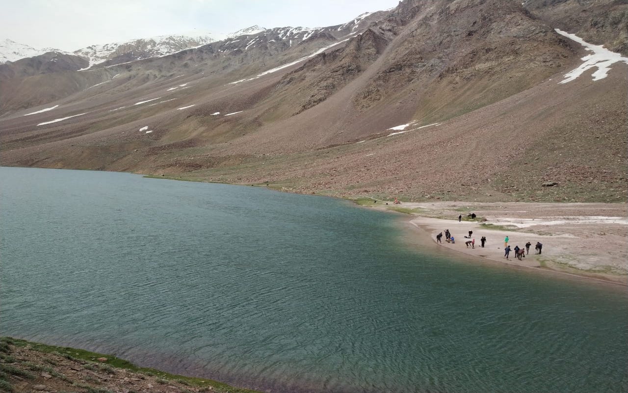 people standing near the chandratal lake