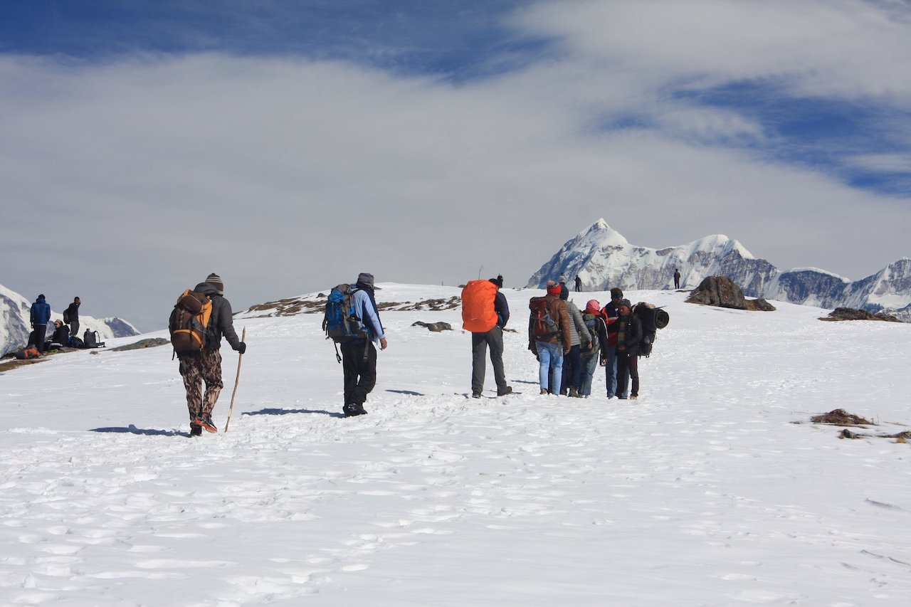 trekkers carying racksack walking toward the brahmatal summit