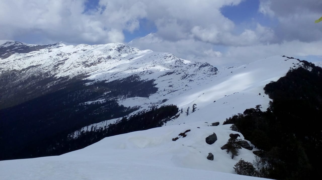 ridge of snow covered mountain at brahmatal trek