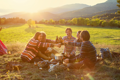 a group of friends toasting beer while on a trek