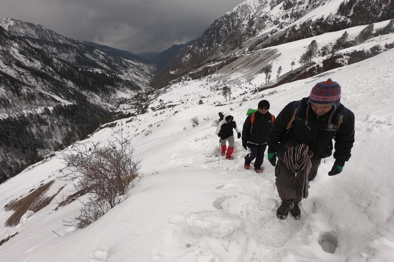 trek leader leading the way through snow covered slope of kalkathiyar dhar