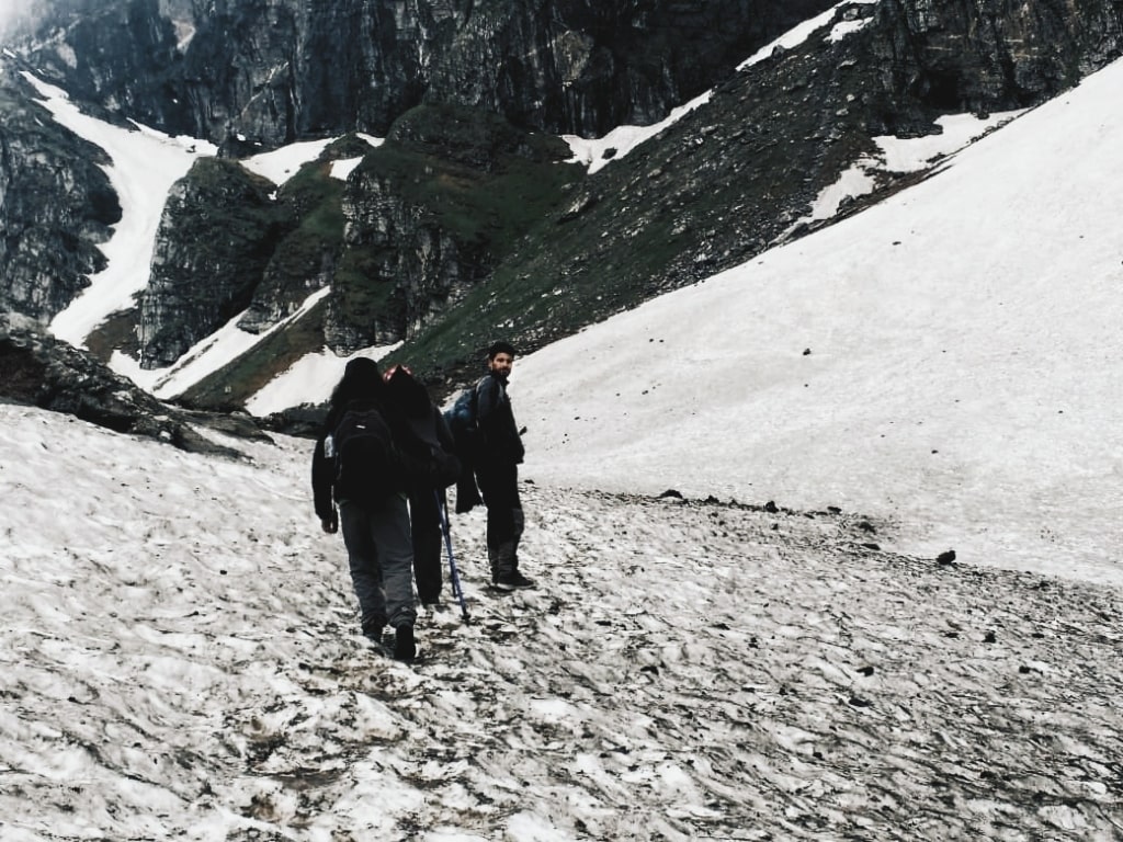 trekkers walking over the snow towards the pass