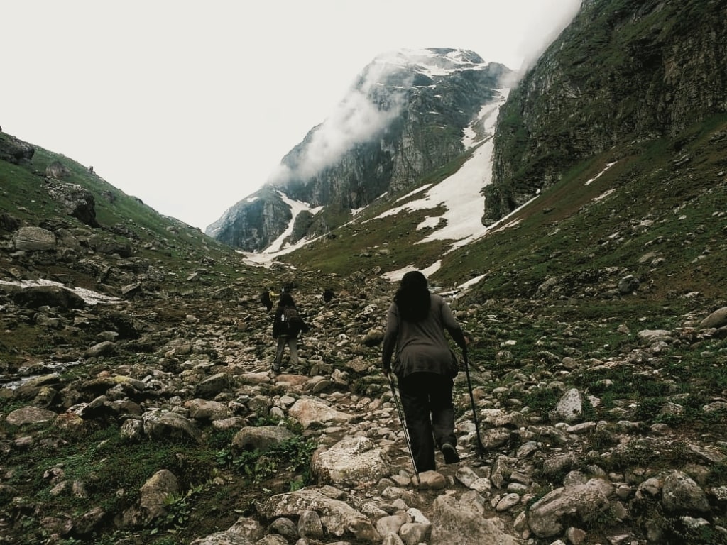 trekkers walking uphill with help of trekkign poles