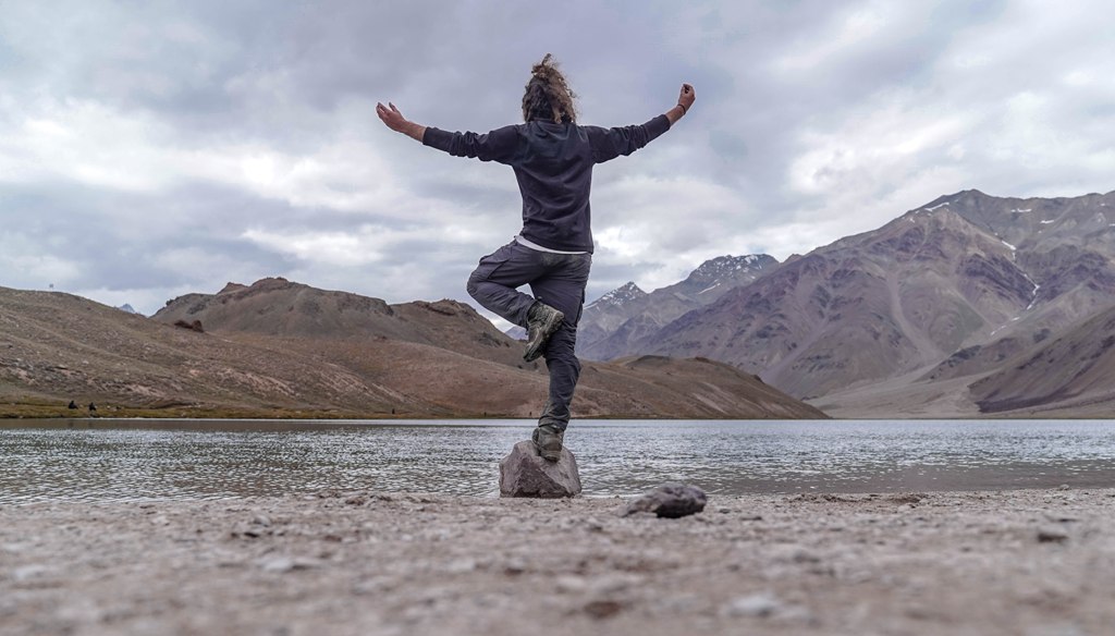 yoga pose by trekker at chandratal lake